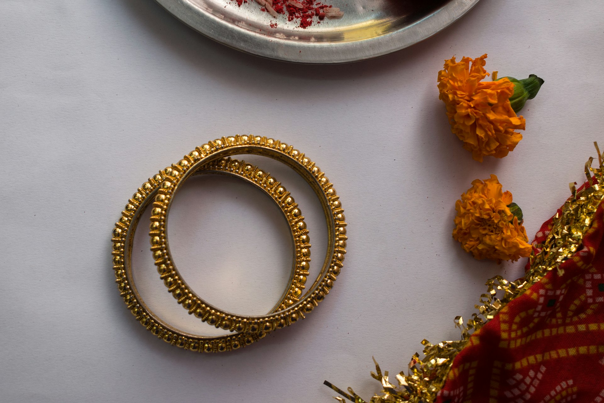 gold and silver bracelet on white table